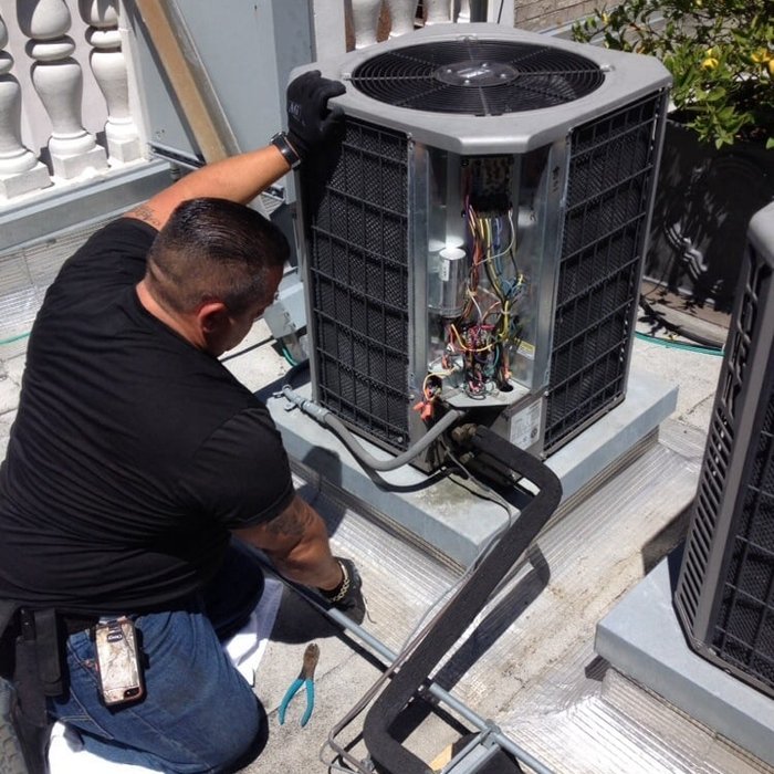 Air Rescue technician servicing a central A/C condenser (project photo)